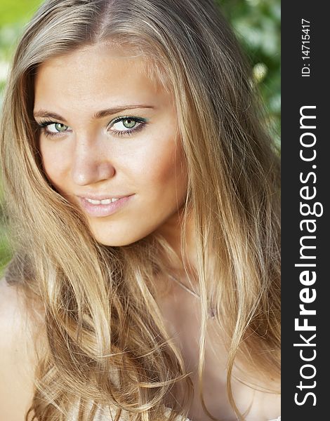 The image of a beautiful girl with long hair in an outdoor