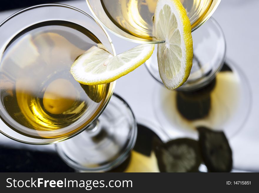 High angle view of martini with olives isolated on black focus on rim of glass and lemon slice. Shallow depth of field. High vew. High angle view of martini with olives isolated on black focus on rim of glass and lemon slice. Shallow depth of field. High vew