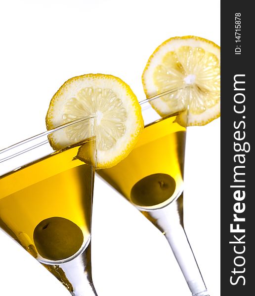 Two glasses with classical martini, garnished olive and lemon. Two glasses with classical martini, garnished olive and lemon.