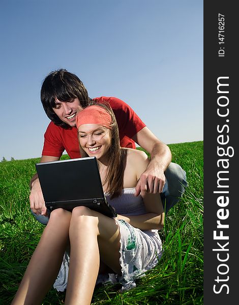 Girl with notebook and boy with smile on grass. Girl with notebook and boy with smile on grass