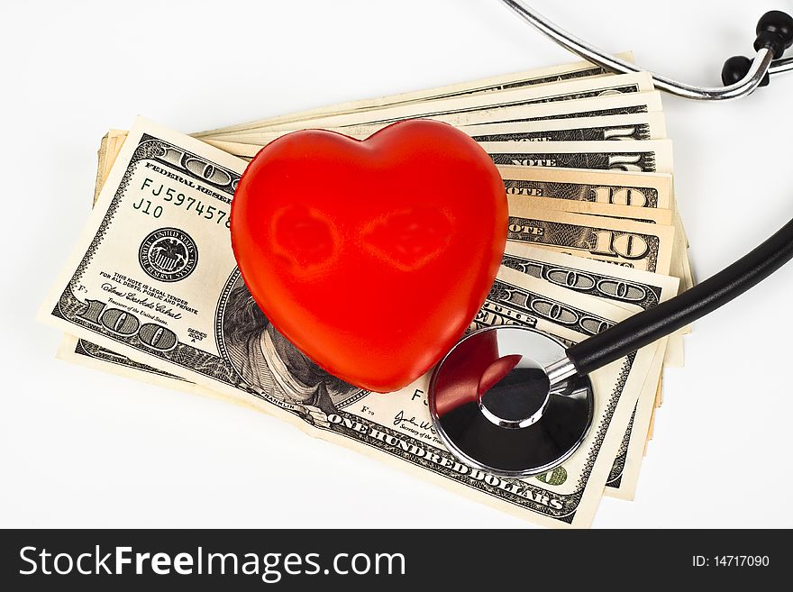 Red heart dollar bills and a stethoscope on white background. Red heart dollar bills and a stethoscope on white background