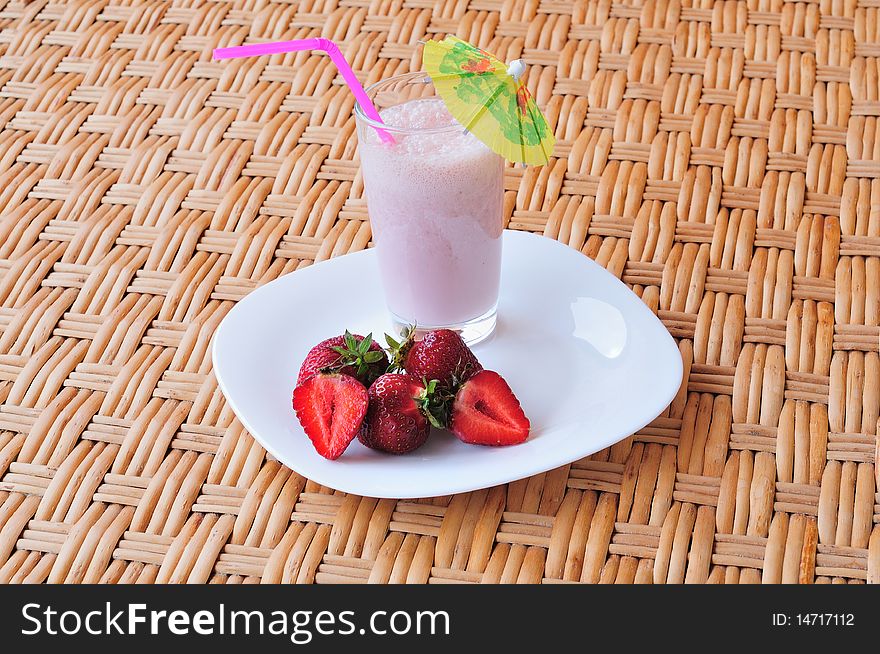 Glass of strawberry milkshake on the table