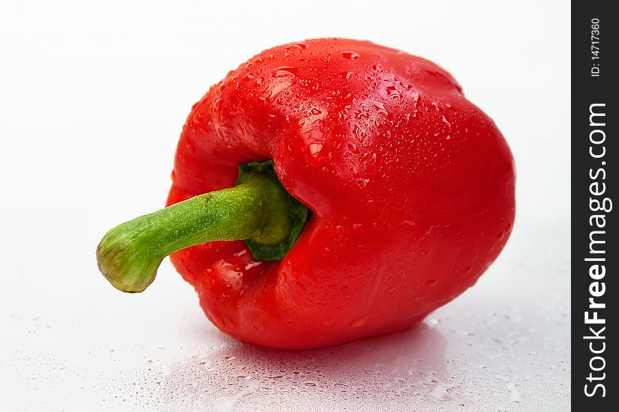 Red Bulgarian pepper with drops of water on a white background. Red Bulgarian pepper with drops of water on a white background.