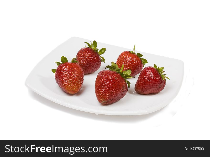 Ripe strawberry on a white plate on a white background