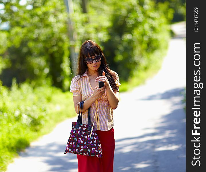Cute girl walking the street and using the phone