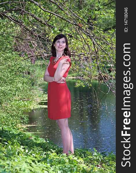 Girl in red dress smiling in a forest. Girl in red dress smiling in a forest