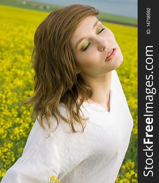 Young girl resting in rape field. Young girl resting in rape field