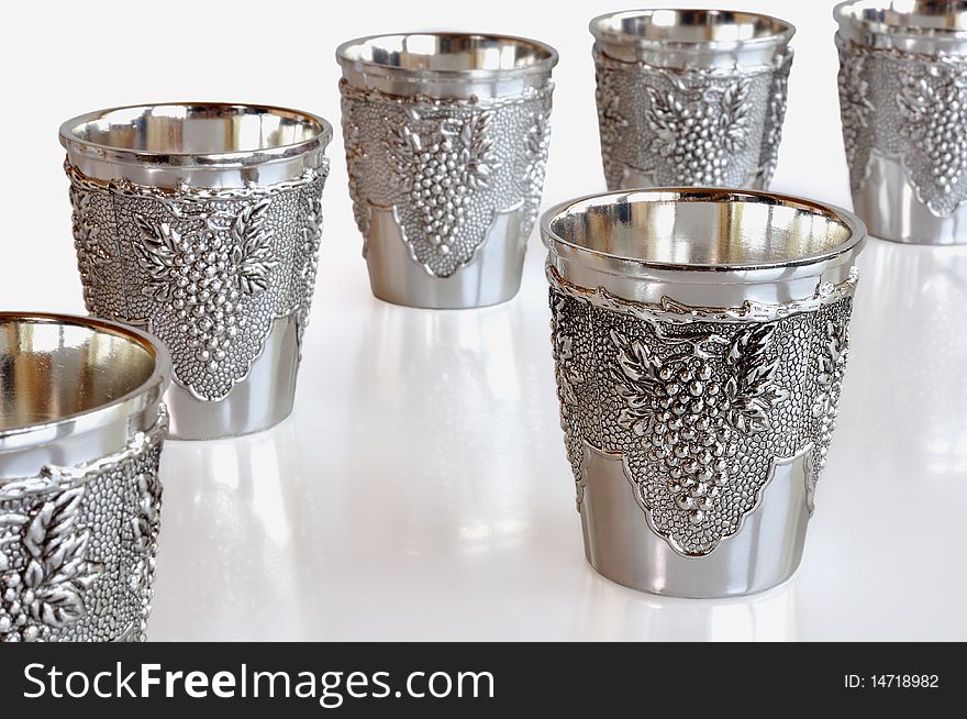 Six metal mini-cups for wine against white background