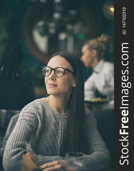 Portrait of pretty young woman in cafe, looking through window and waiting for someone. Portrait of pretty young woman in cafe, looking through window and waiting for someone