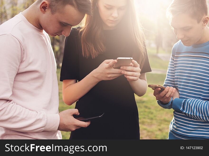 The Group Of Young Friends Teenagers Using Mobile At City Street