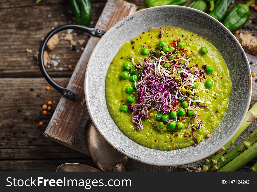 Healthy green pea soup served in bowl