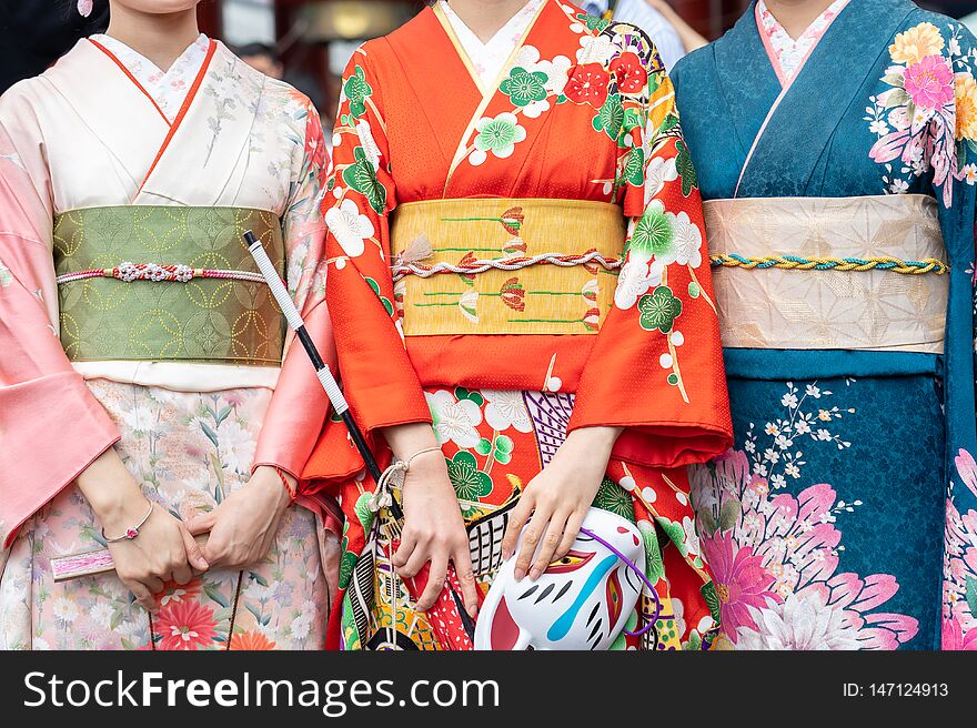 Young girl wearing Japanese kimono standing in front of Sensoji Temple in Tokyo, Japan. Kimono is a Japanese traditional garment. The word `kimono`, which actually means a `thing to wear