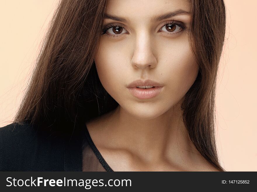 Close Up Of A Brunette Girl With Seductive And Natural Make Up, Long Hair, Looking At Camera, Dressed In Black.