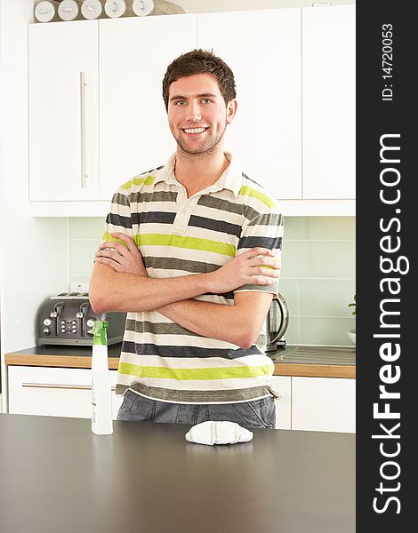 Young Man Cleaning Modern Kitchen Smiling At Camera