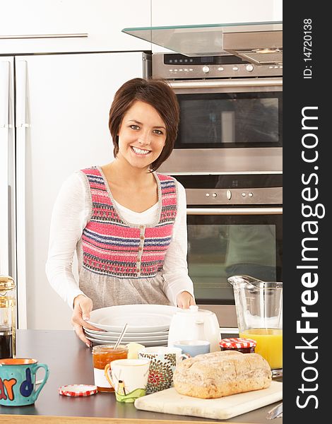 Young Woman Preparing Meal In Modern Kitchen Smiling At Camera