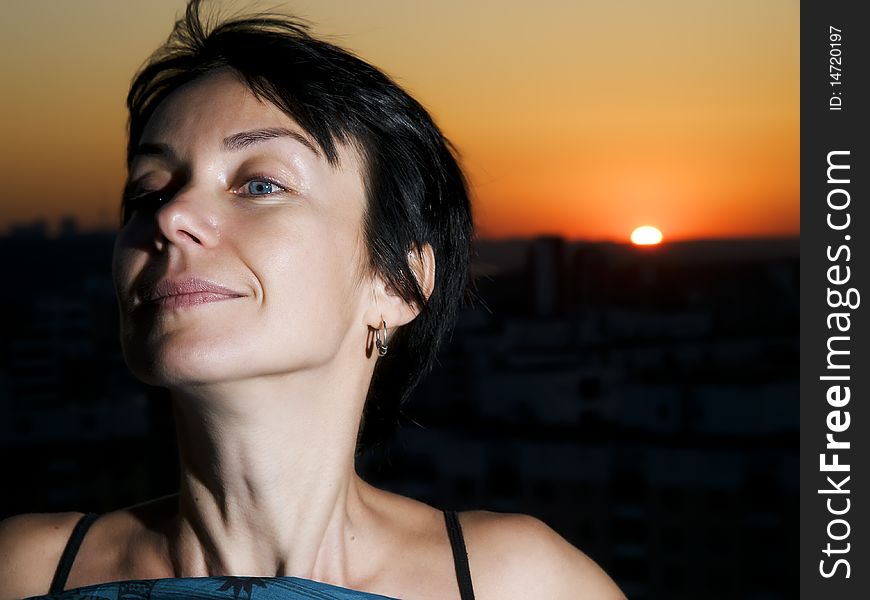 Woman on a cities roof against a sunset. Woman on a cities roof against a sunset