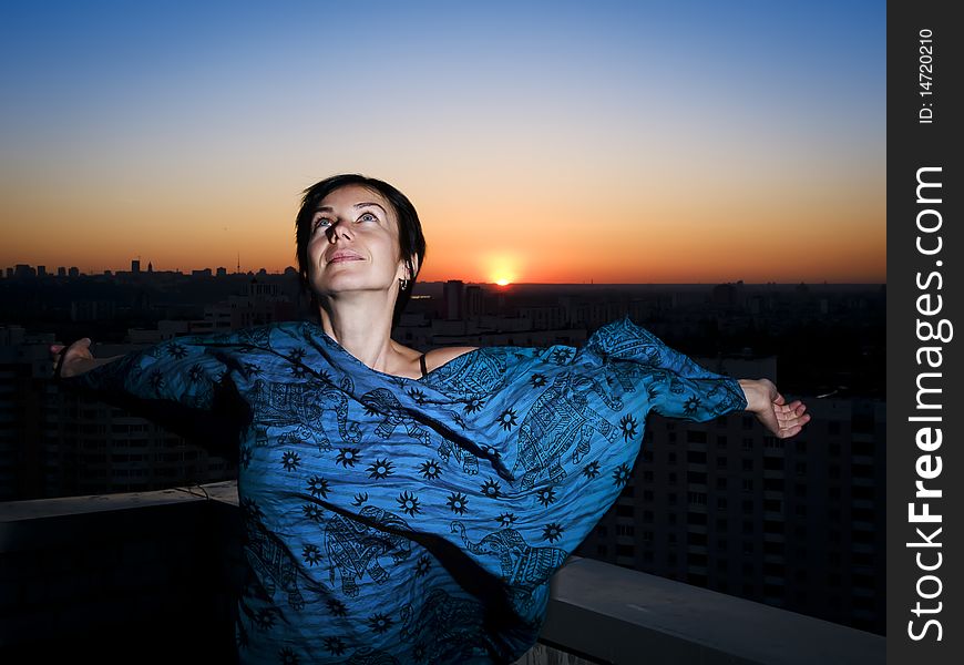 Woman, sunset in a city and dusk blue sky