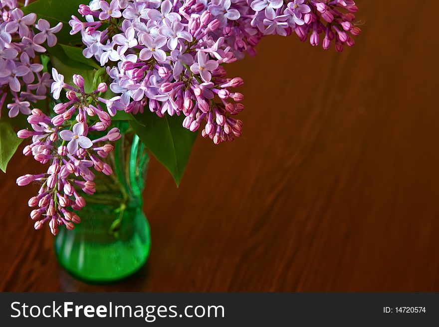 Close-up purple lilac in green vase. Close-up purple lilac in green vase