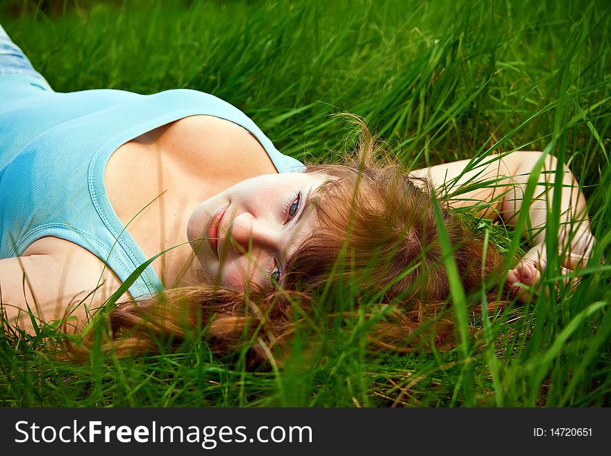 Portrait of a beautiful female lying on a grass, it is summer and she is relaxing. Portrait of a beautiful female lying on a grass, it is summer and she is relaxing