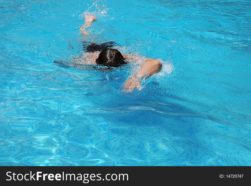 A man swims in the freestyle in the pool. A man swims in the freestyle in the pool