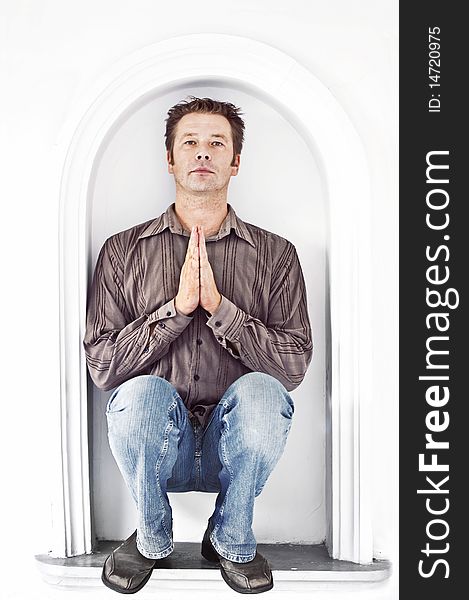 Man on a white background praying looking straight at the camera. Man on a white background praying looking straight at the camera