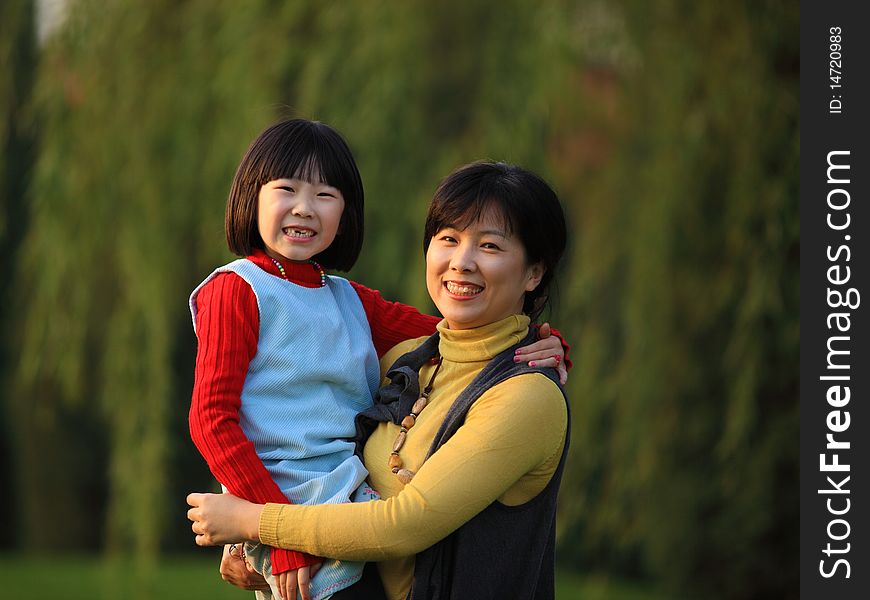The Chinese mother holding her daughter in autumn. The Chinese mother holding her daughter in autumn