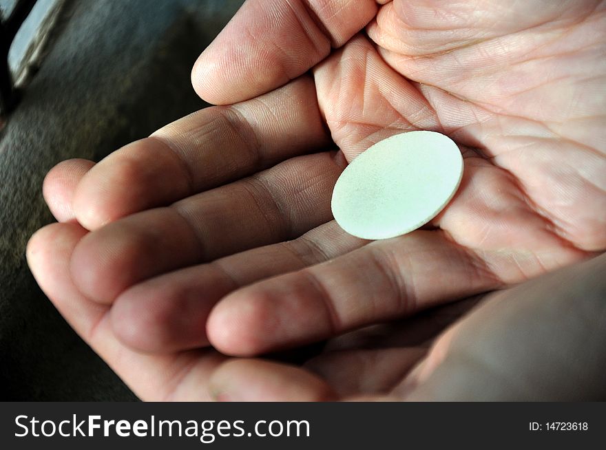 Mans hands hold a wafer close to the window in a church. Mans hands hold a wafer close to the window in a church