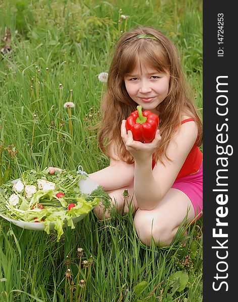 Portrait of the girl on a green grass with a dish of fresh vegetables. Portrait of the girl on a green grass with a dish of fresh vegetables