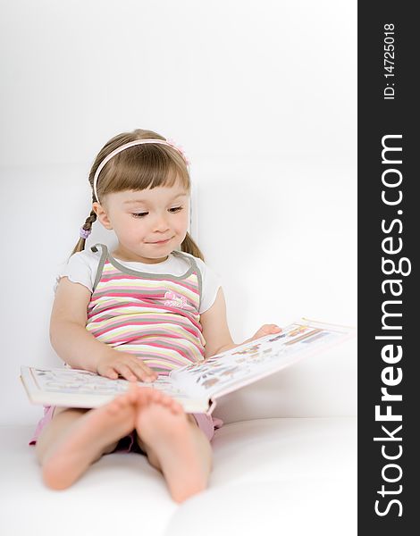 Sweet happy little girl reading book