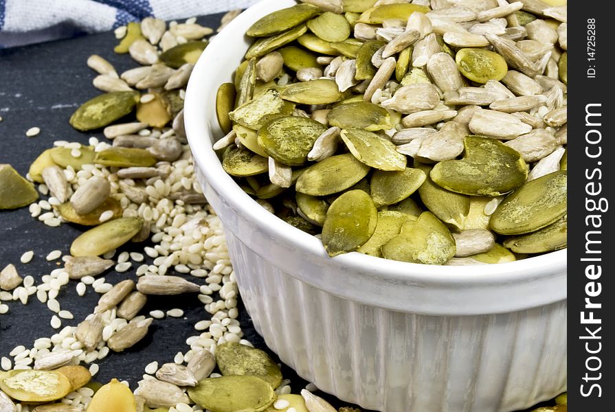 White bowl filled with a mix of pumpkin, sunflower and sesame seeds. White bowl filled with a mix of pumpkin, sunflower and sesame seeds