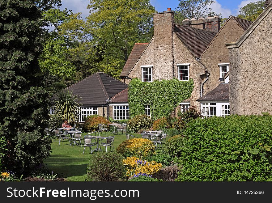 Young man reading the morning papers in the garden of a country hotel. Young man reading the morning papers in the garden of a country hotel