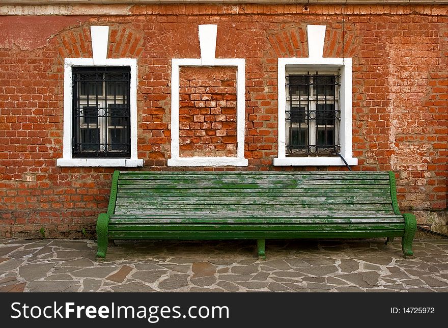 Old brick wall, two windows and a bench. Old brick wall, two windows and a bench