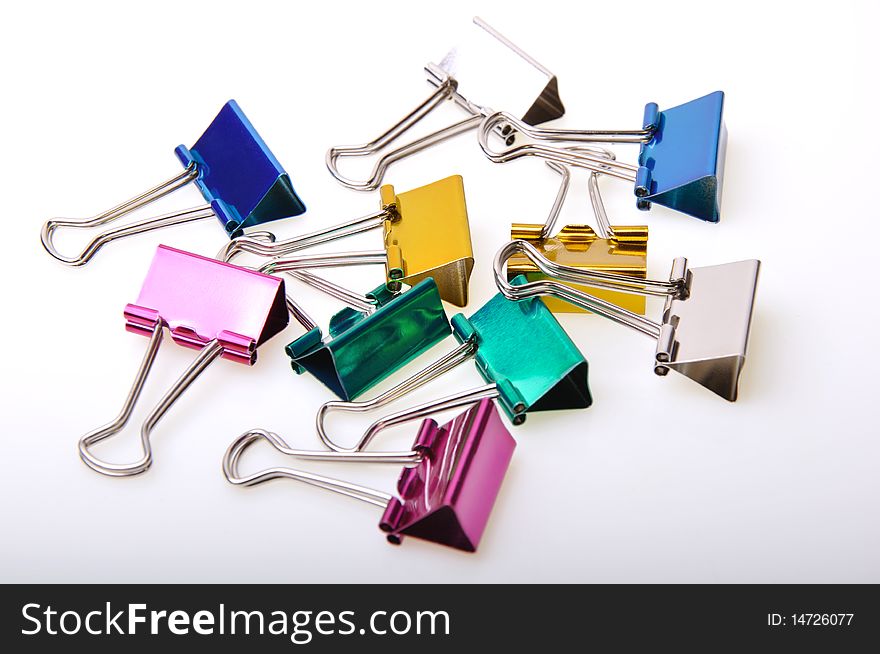 Metallic colored paper clip on a white board