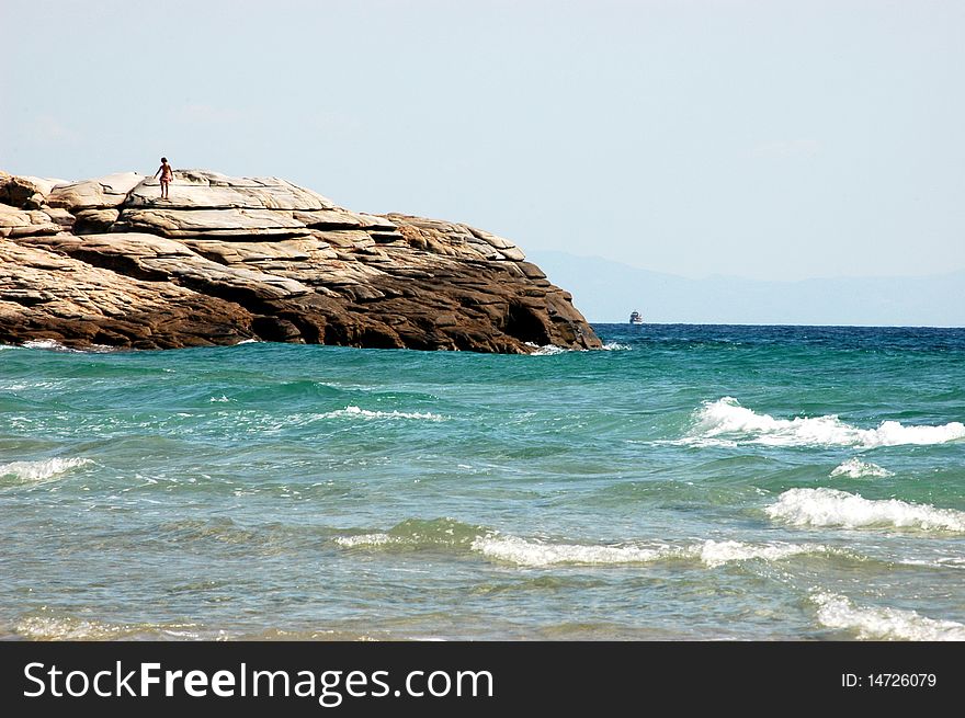 A boy walking on the rocky coast. A boy walking on the rocky coast