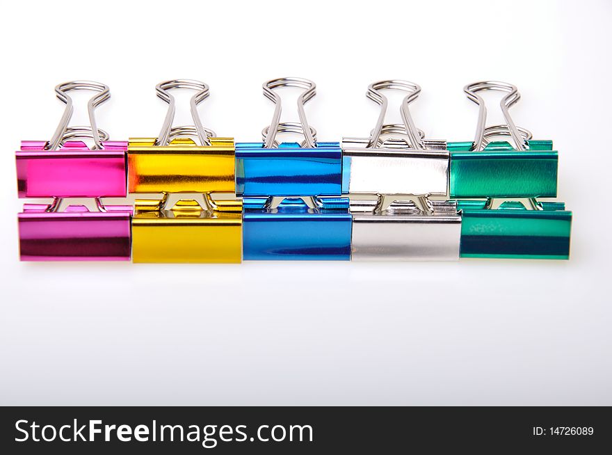 Line of paper clip metallic colored on a white board