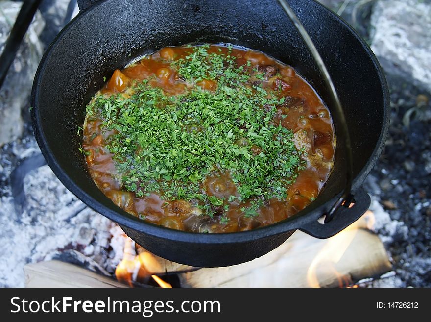 This picture represents an outdoor cooking session in a cauldron!