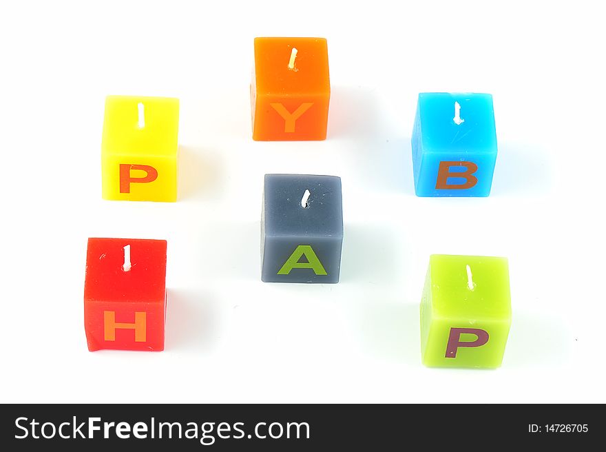 Colorful cubic candles with letters of the word Happy