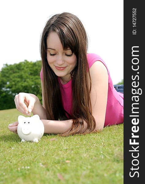 Young woman putting coin in piggy bank. Young woman putting coin in piggy bank