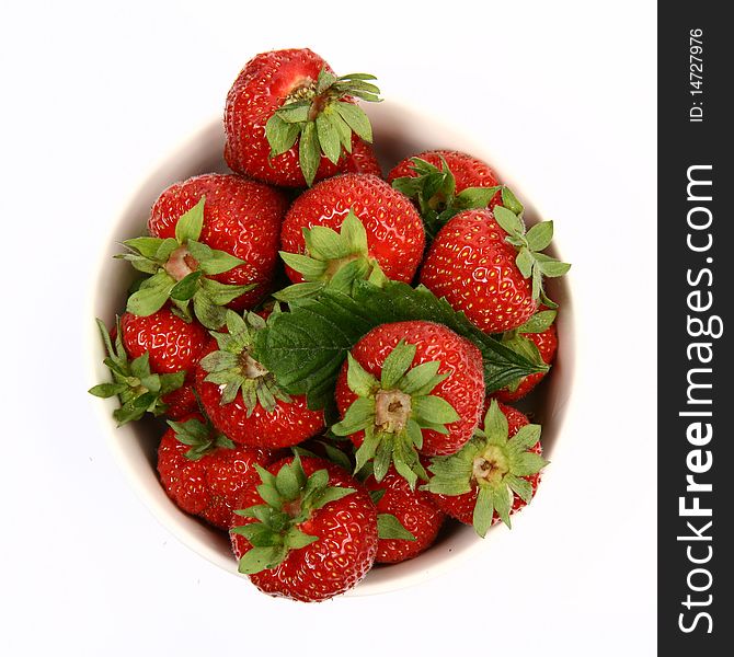 Strawberries in a bowl in close up on white background