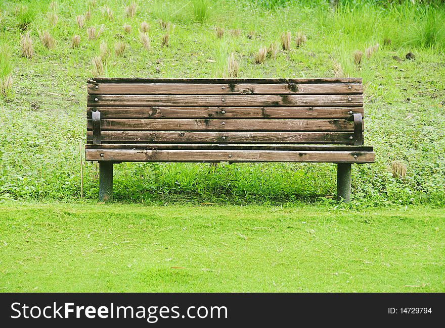 Wooden bench in a grassy area of golf course