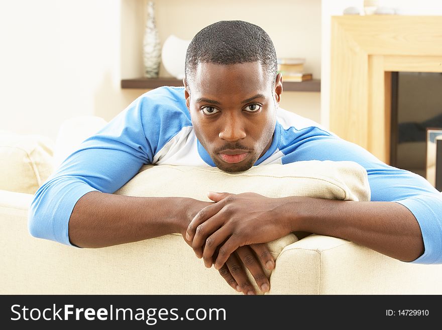 Man Relaxing On Sofa At Home At Camera