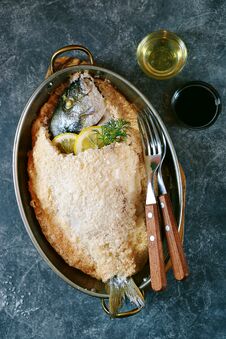 Sea Fish, Dorado Fish Baked In Coarse Salt Mixed With Egg White. Healthy Food. Top View. Stock Photo Sea Fish, Dorado Fish Baked In Coarse Salt Mixed With Egg White. Healthy Food. Top View. Stock Photo