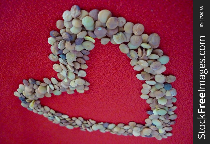 A heart of lentils on a red background