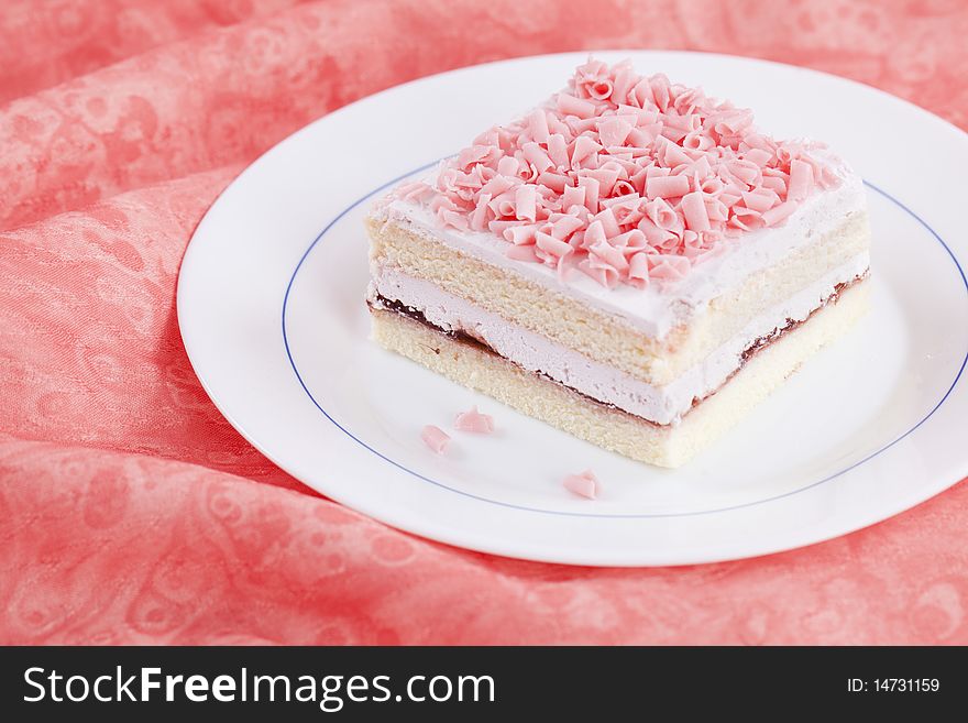 Close up of slice of fresh sweet cake on pink texture