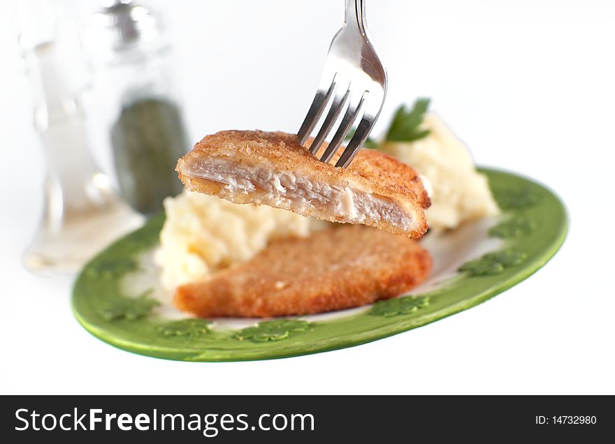 Chicken fillet, focus on fork and steak, isolated on white