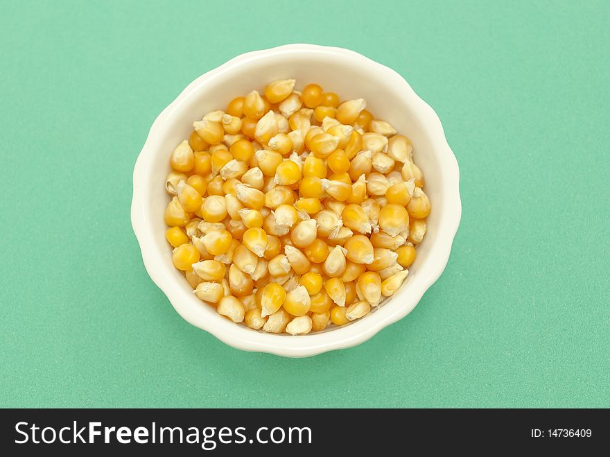 Yellow corn kernels macro photography close-green background