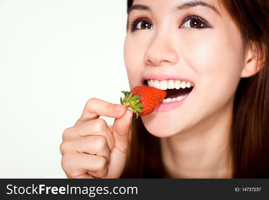 Cheerful picture of an attractive young woman biting a strawberry. Cheerful picture of an attractive young woman biting a strawberry