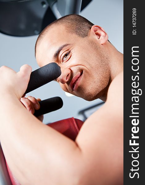 Close-up of an attractive male working out at the gym, looking at the camera. Close-up of an attractive male working out at the gym, looking at the camera