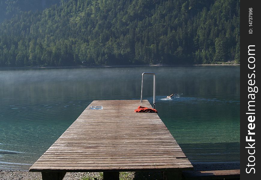 Lake Plansee in Austria, a swimmer early in the morning. Lake Plansee in Austria, a swimmer early in the morning