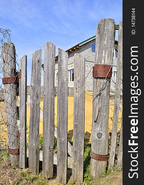 The old wooden lop-sided gate to the house. The old wooden lop-sided gate to the house